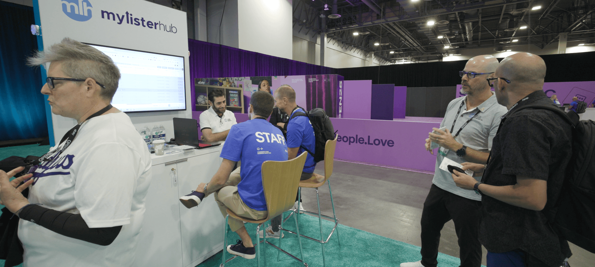 MyListerHub booth at eBay Open 2025 in Las Vegas, where attendees and staff engage in live software demos and conversations about eBay automation tools